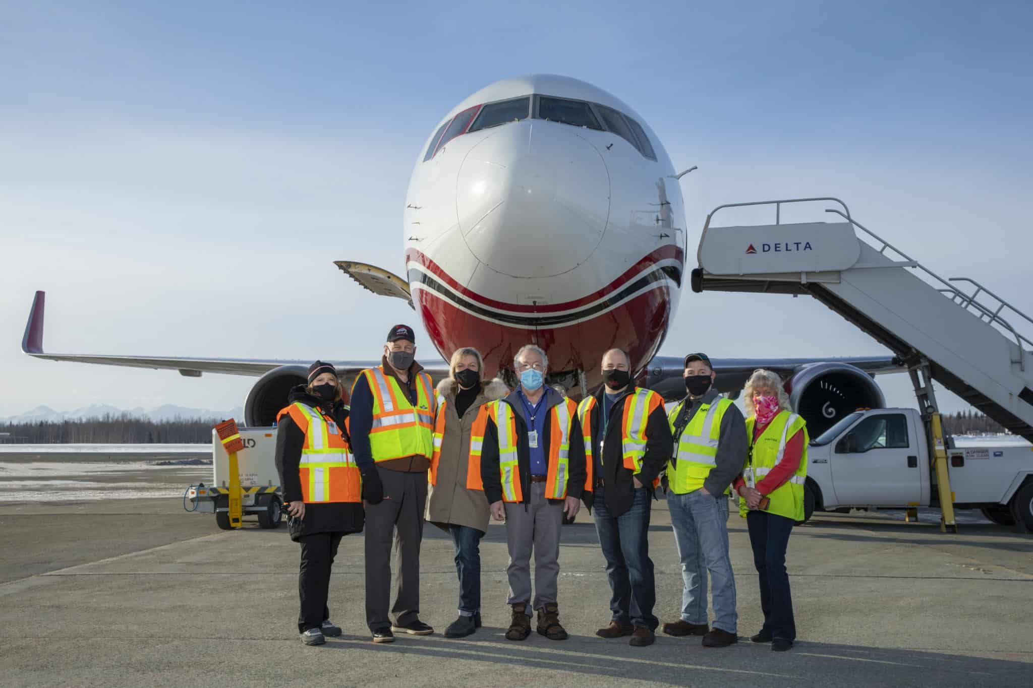 Employees standing in front of a Northern Air Cargo plane.