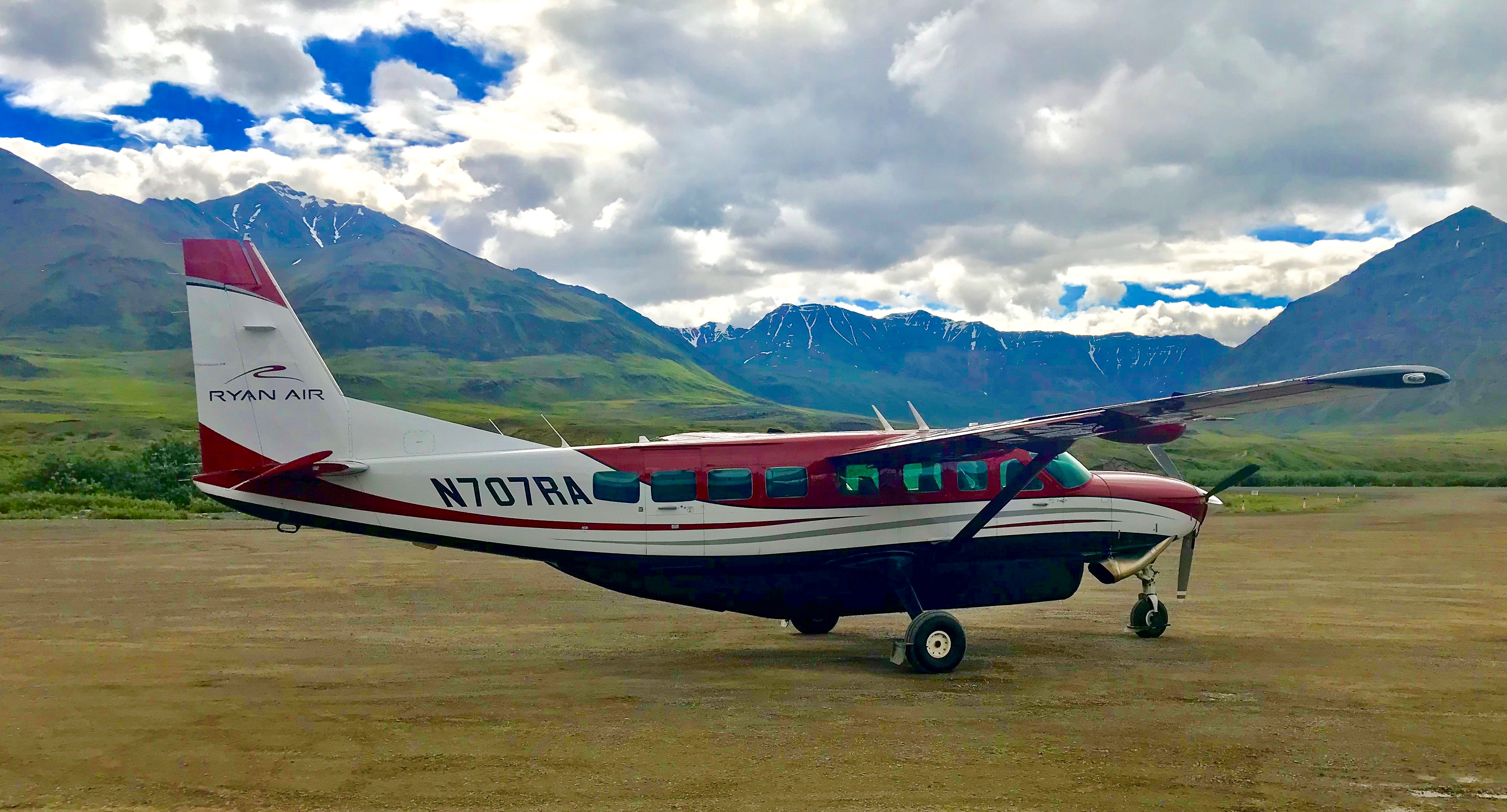 Photo of a Cessna 208 plane on a grassy plane in Alaska