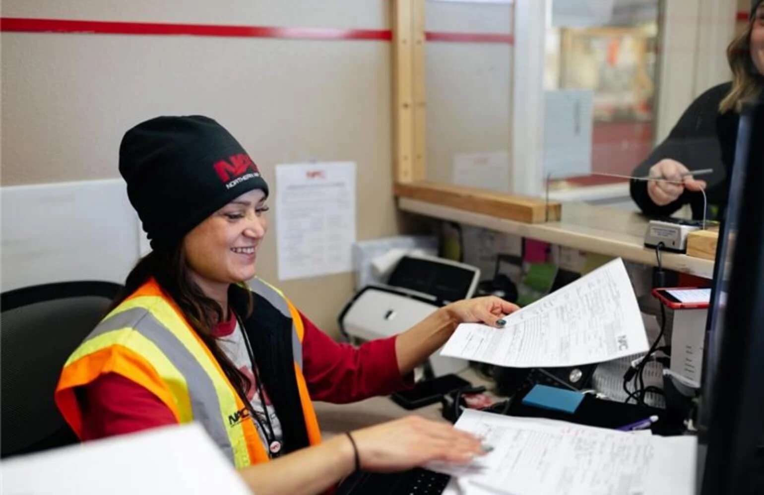 A NAC Customer Service agent helping a customer with paperwork.