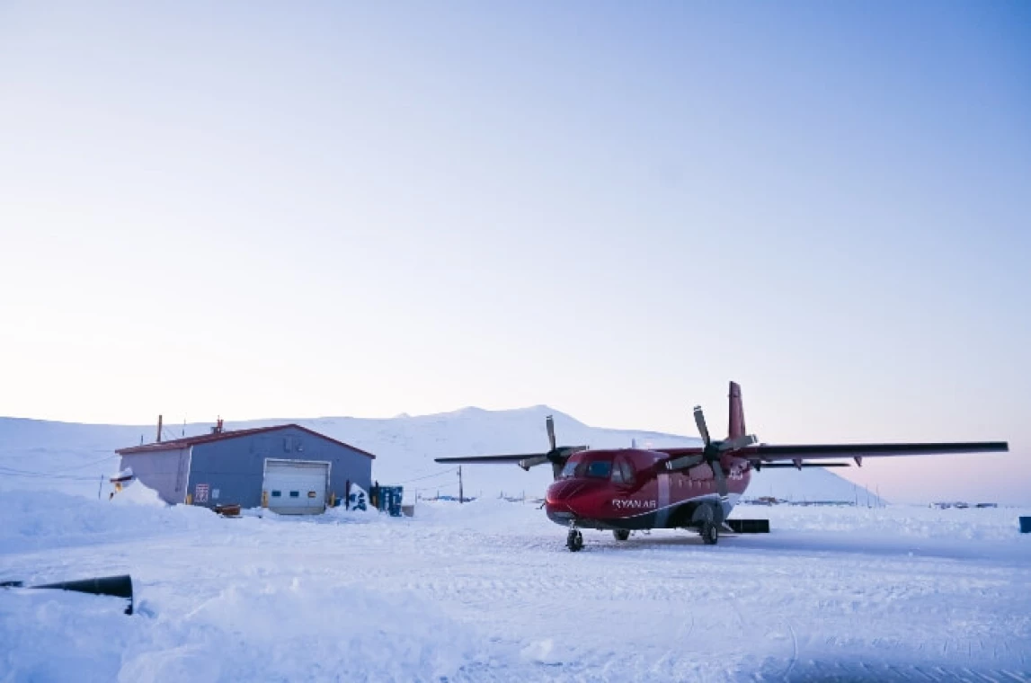 A small plane on a snowy runway.