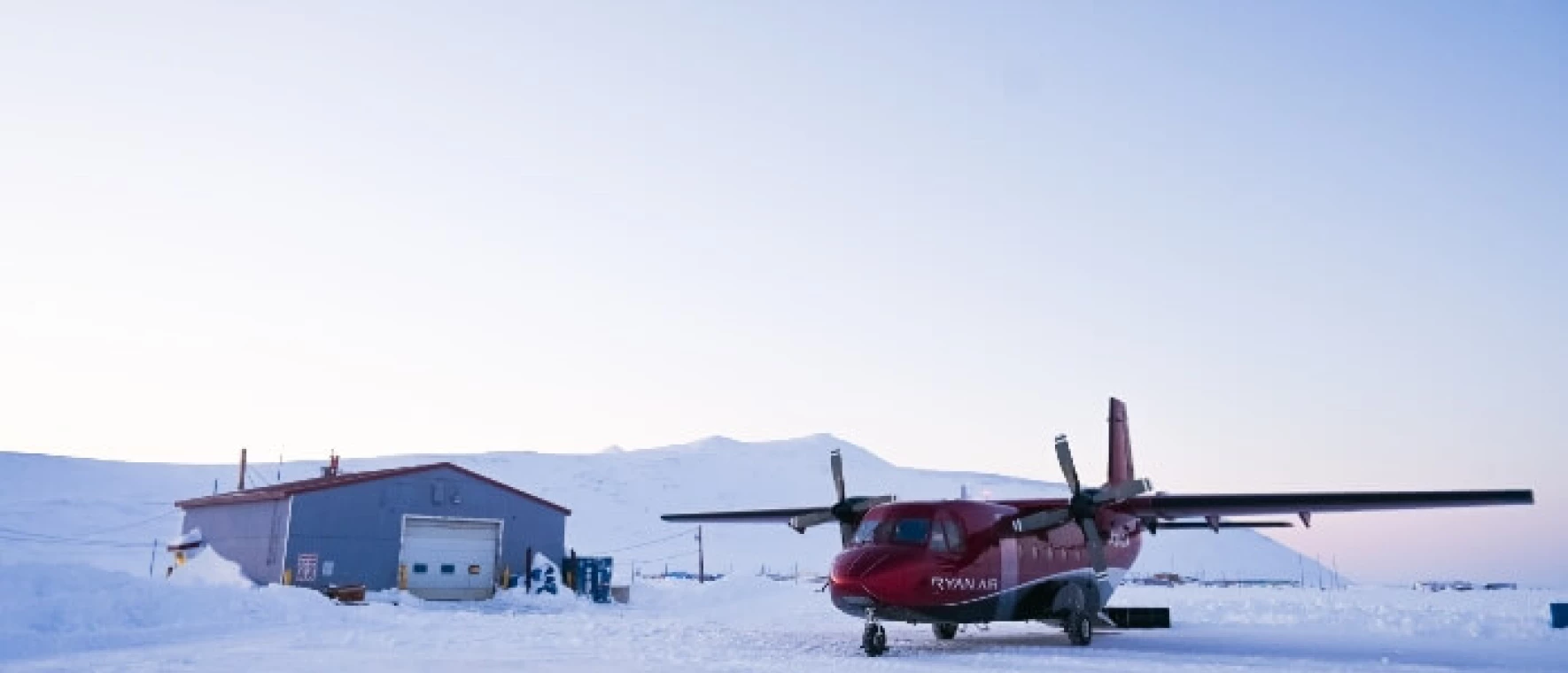 A small plane on a snowy runway.