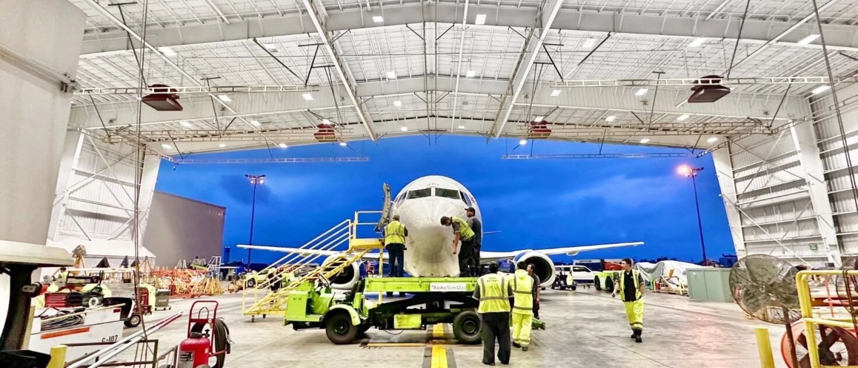 Aloha Tech Ops employees work on a plane parked in the Maintenance hangar.
