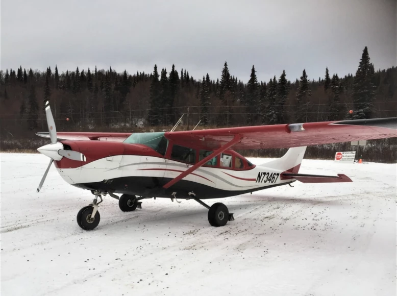 Photo of a Cessna-207 plane sitting on a snowy runway.