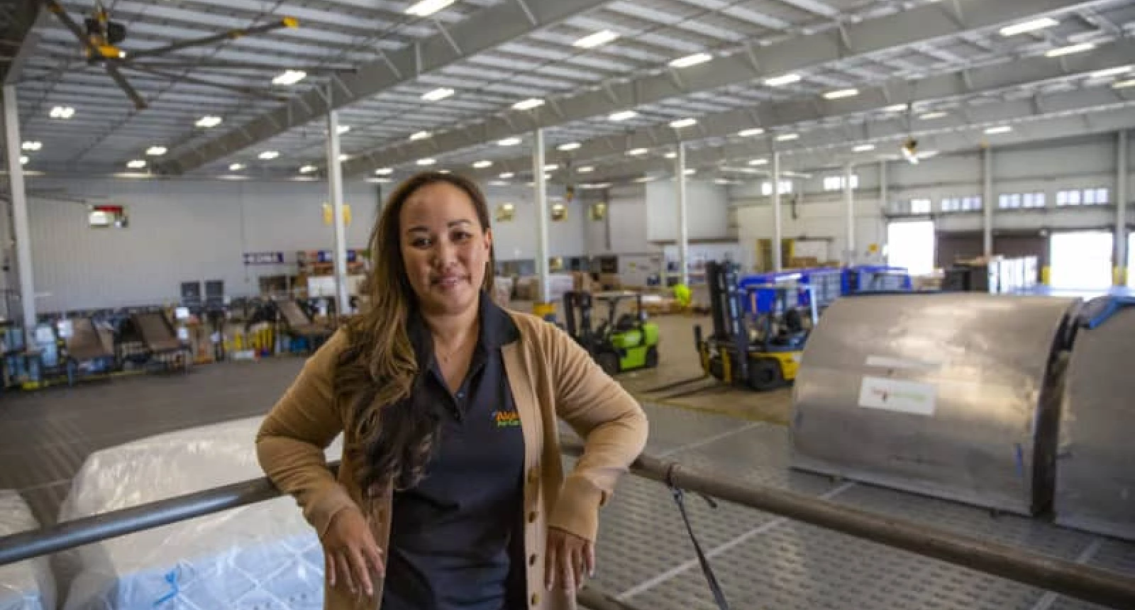 Photo of Aloha Air Cargo employee Coleen Kaneshiro standing in a cargo warehouse.