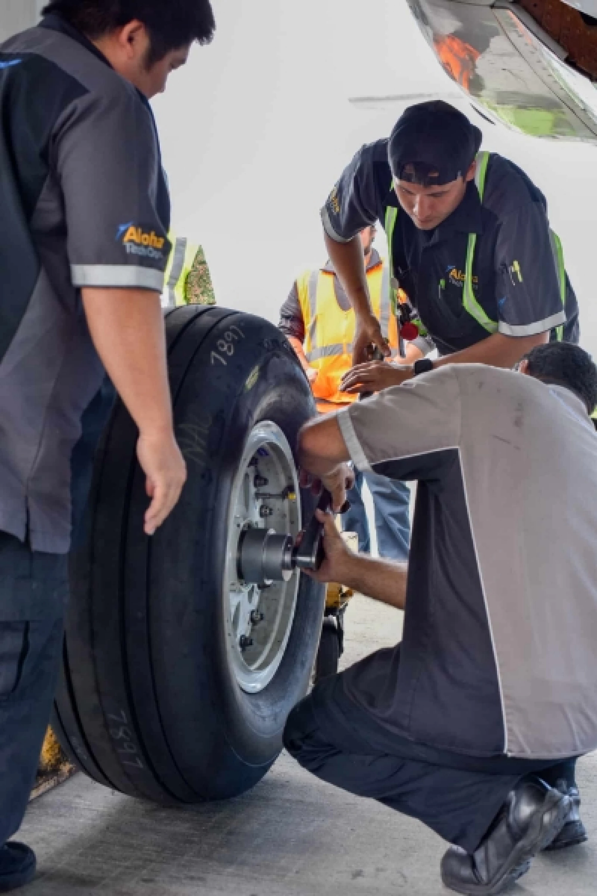 Photo of Aloha Tech Ops employees working on an airplane tire.