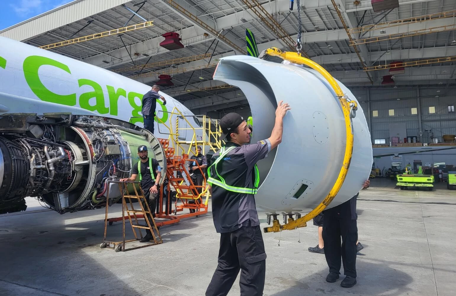 Aloha Tech Ops employee carryinig a plane part.