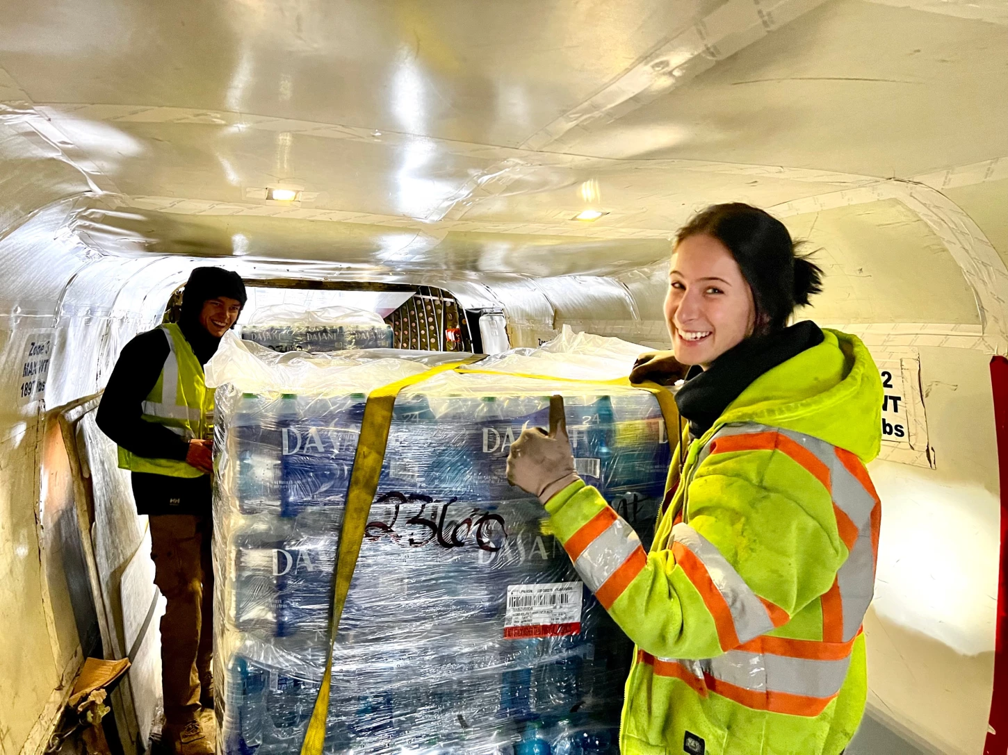 Ryan Air employees loading pallets of water into a plane.