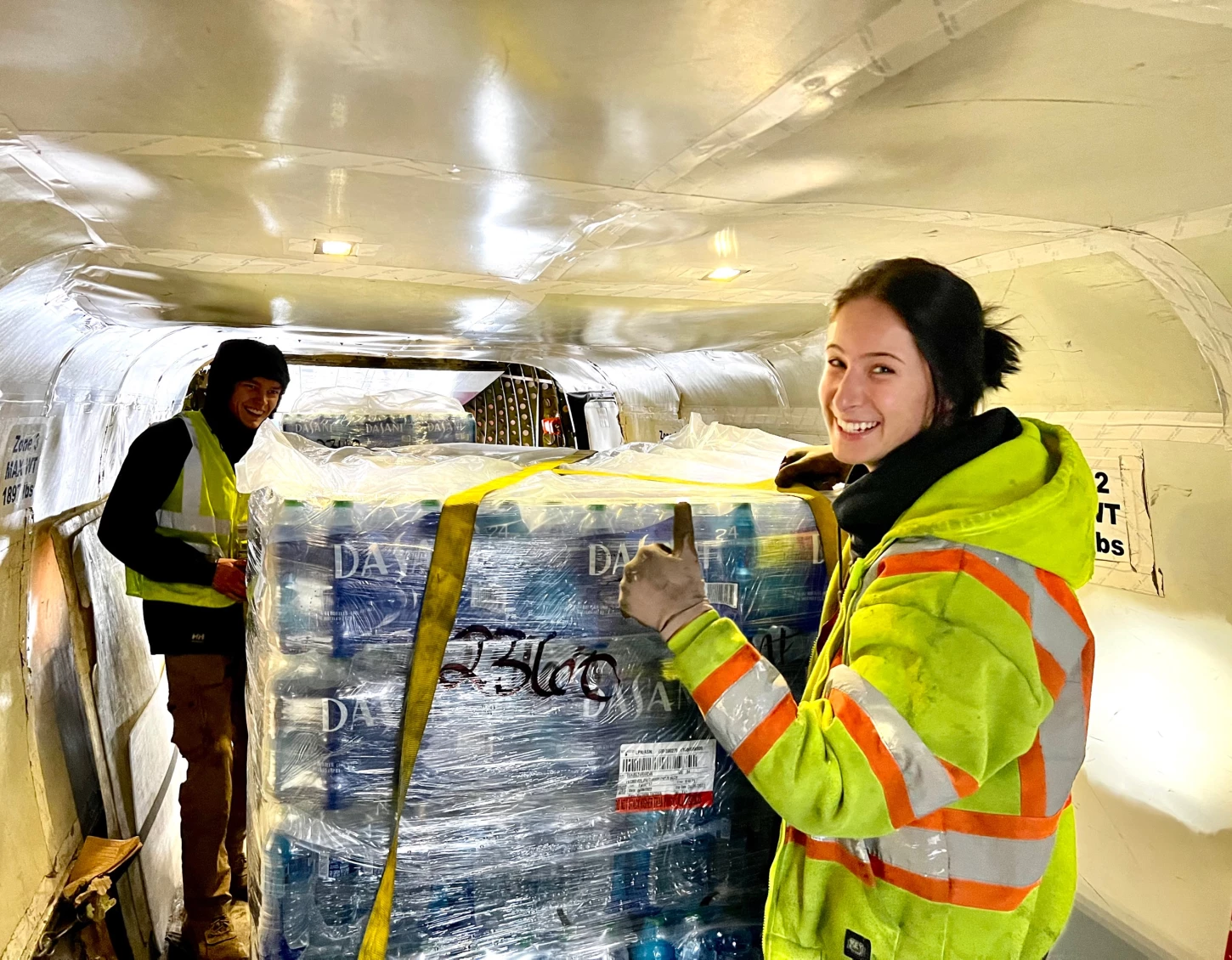 Ryan Air employees loading pallets of water into a plane.